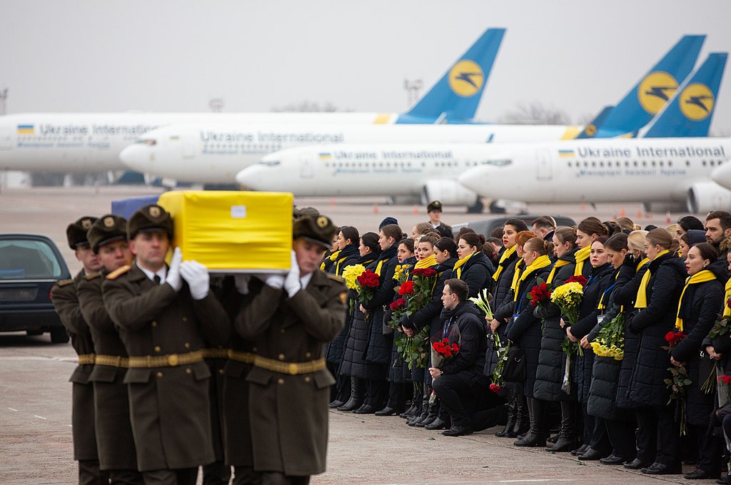 Coffin bearers and crowds commemorate victims of UIA flight 752.