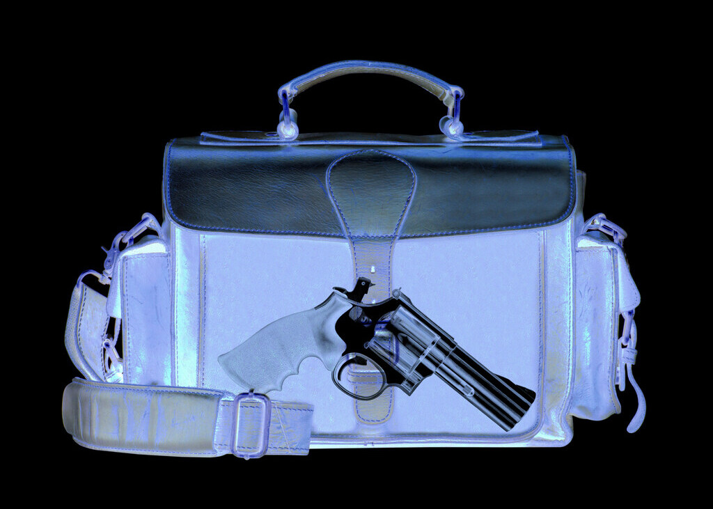 X-ray picture of travel bag with hand gun inside.