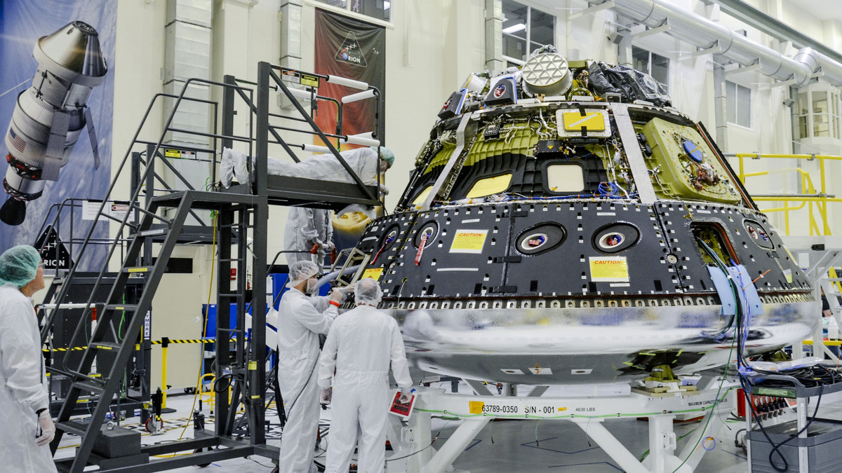Technicians work on the Orion crew module for NASA’s Artemis II mission
